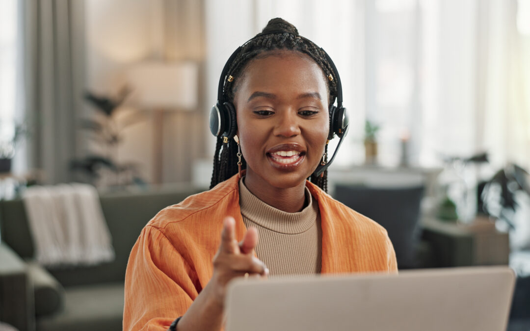 Black woman, headset with laptop and phone call, virtual assistant or crm in home office. Remote work girl at desk with computer, typing and conversation for advice, online chat and help in apartment.